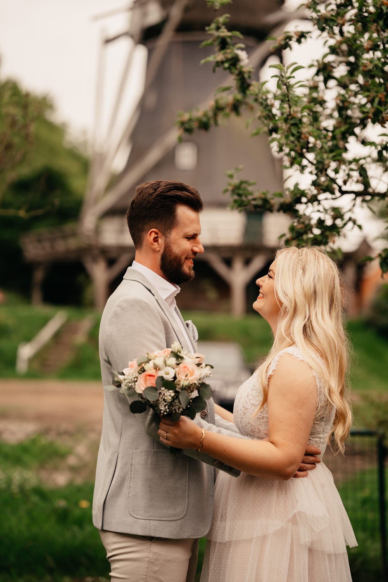 Brautpaar mit der Mühle im Hintergrund am Müllerhaus Brunsbrock – Anna Lorek Fotografie