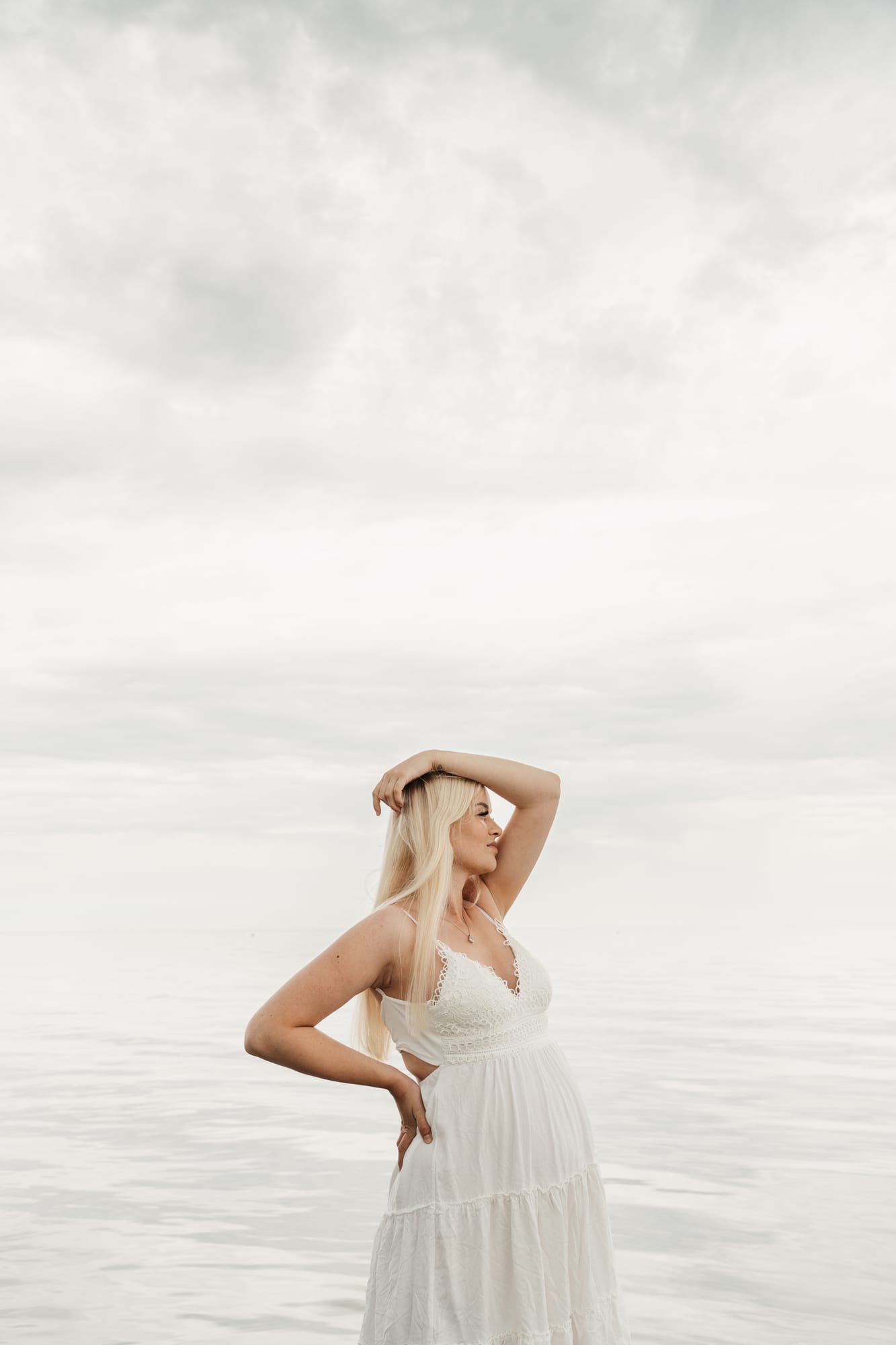 Babybauch-Portrait im weißen Kleid am Meer