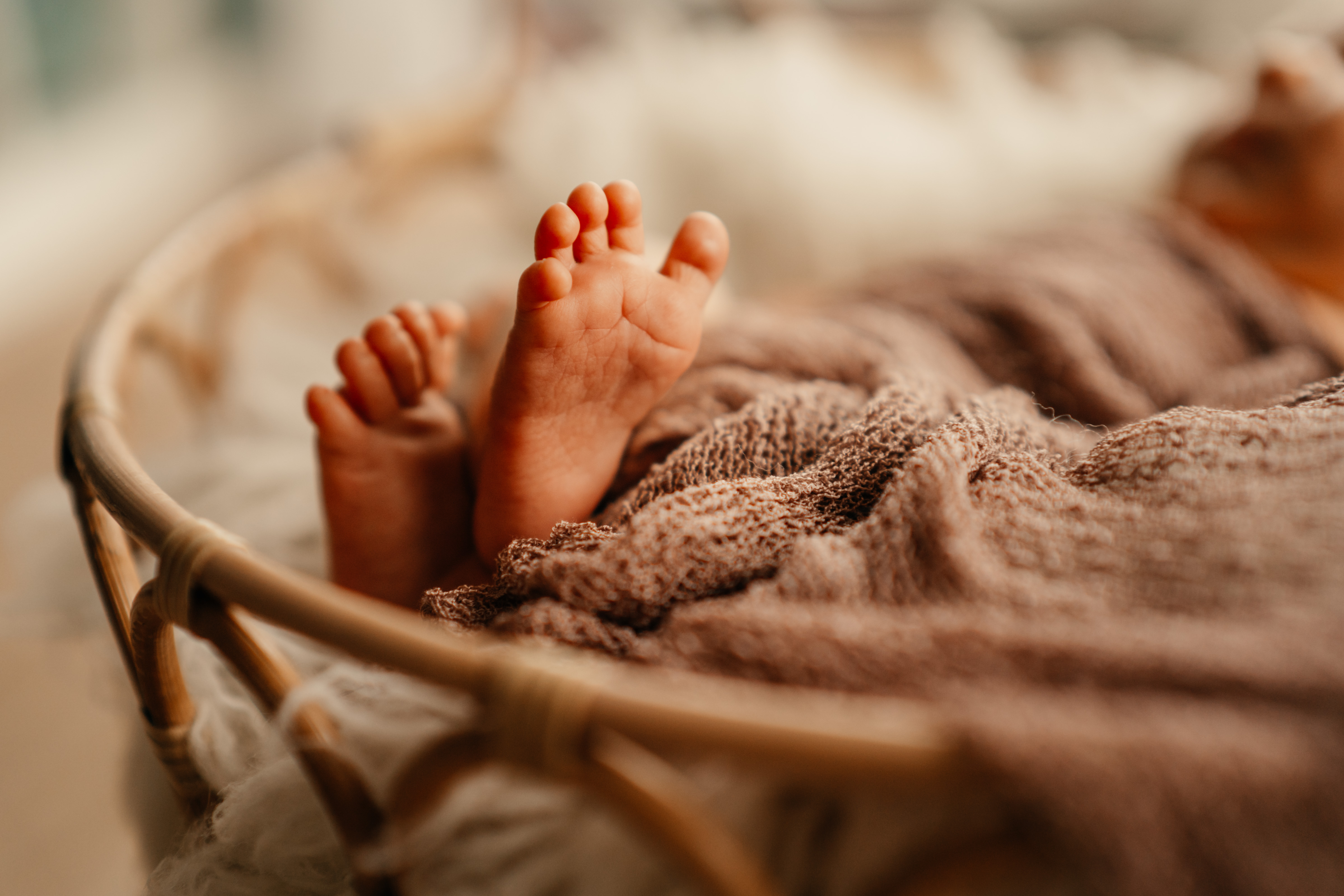 Mama hält ihr Neugeborenes auf der Brust im warmen Tageslicht